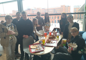 Uczniowie jedzą pizzę w restauracji