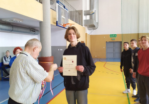 Kapitan drużyny przyjmuje pamiątkowy dyplom.