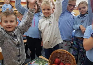 Uczniowie wyciągają jabłka z koszyka