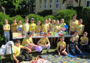 Uczniowie wraz z wychowawcą piknikują na świeżym powietrzu.