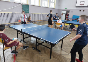 Uczniowie grają w tenisa stołowego.
