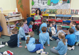 Uczniowie słuchają opowiadania pisarki.