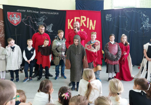 Uczniowie klas młodszych uczestniczący w rycerskim przedstawieniu.