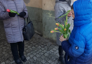 Uczniowie wręczają kwiaty mieszkankom Brzezin.
