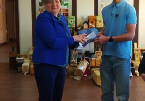 Burmistrz Miasta Brzeziny wręcza nagrodę uczniowi.
