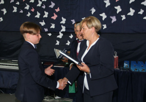 Pani Burmistrz wręcza dyplom i nagrodę uczniowi.