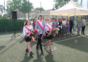 Zdjęcie delegacji uczniów niosących kwiaty pod pomnik upamiętniający wybuch II wojny światowej.