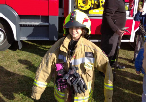 Dziewczynka w stroju strażaka.