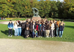 Pamiątkowe zdjęcie uczniów pod pomnikiem Fryderyka Chopina.