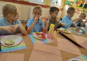 Uczniowie spożywają przygotowane przez siebie zdrowe śniadanie.