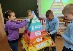 Uczniowie wykonują przestrzenną piramidę żywienia.