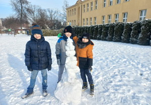 Uczniowie prezentują swoją budowlę z lodu.
