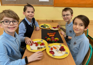 Uczniowie przygotowują pracę plastyczno - techniczną z owoców i warzyw.
